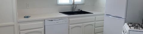 A kitchen with white cabinets and a wooden counter.