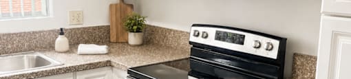 A kitchen with a stove top oven and microwave above it.