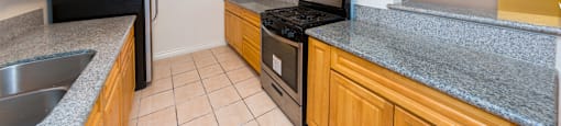 A kitchen with wooden cabinets and a black refrigerator.