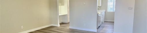 A room with wooden flooring and white walls.