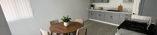 A kitchen with a table and chairs in the middle of the room.