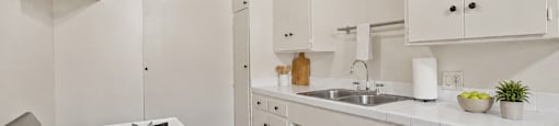 A white kitchen with a stove and cabinets.