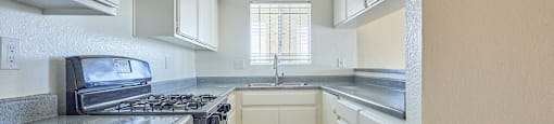 A kitchen with a stove top oven and a sink.