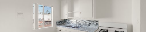 A kitchen with a stove, oven, and a fan.