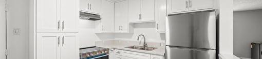 A kitchen with white cabinets and stainless steel appliances.