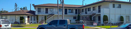 a building with palm trees and a truck parked in a parking lot