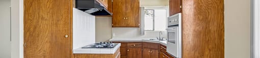 A kitchen with wooden cabinets and a stove top oven.