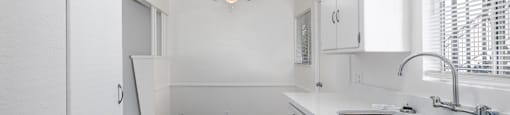 A kitchen with a sink, faucet, and a ceiling fan.