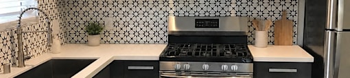 A modern kitchen with black and white tiles.