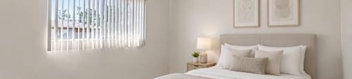 A bedroom with a large bed and two picture frames on the wall.