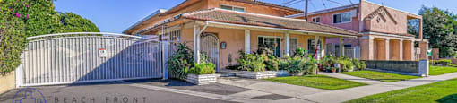 a house with a white gate and a driveway in front of it