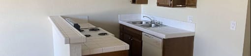 A kitchen with a white stove top oven and a white dishwasher.