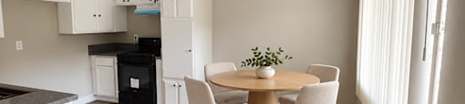 A kitchen with a table and chairs.