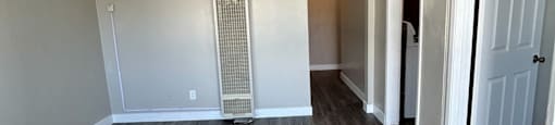 an empty living room with wood flooring and white walls
