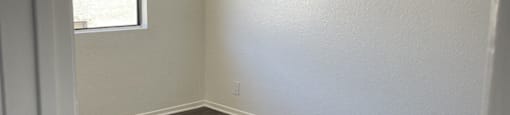 an empty room with a ceiling fan and a window