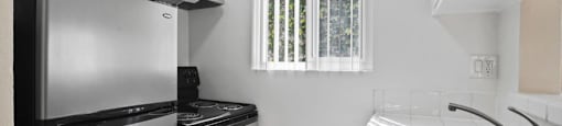 A kitchen with a black refrigerator, stove, and microwave.