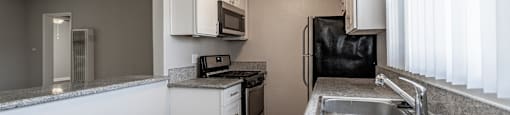 A kitchen with a sink, stove, and refrigerator.