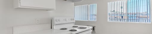 A kitchen with white appliances and cabinets with a logo for Beach Front Property Management.