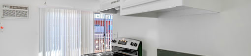 A kitchen with a stove and a fan on the ceiling.