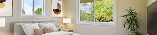 a bedroom with a bed and two windows