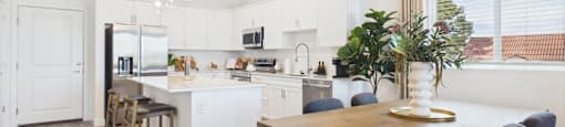 A modern kitchen with a dining table and chairs.