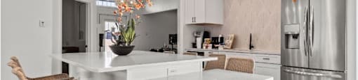 a kitchen with a large island and a stainless steel refrigerator