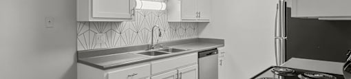 an empty kitchen with white cabinets and stainless steel appliances