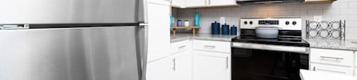 a kitchen with stainless steel appliances and white cabinets