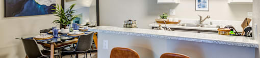 A kitchen with a dining table and chairs.