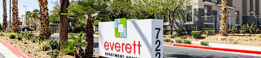 A sign for Everett Apartment Homes is in front of a building.
