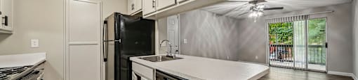 A kitchen with black appliances and white cabinets.
