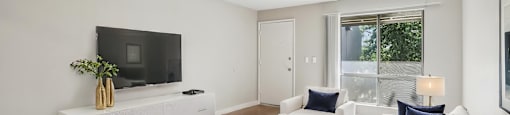A living room with white furniture and a flat screen TV.