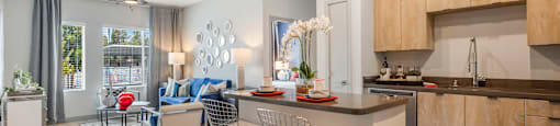 A modern kitchen with a dining area and a living room.