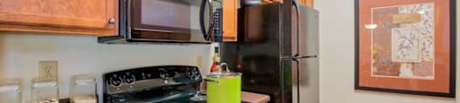 Hinesville, GA Apartments – Tattersall Village - kitchen with hardwood floors and black appliances