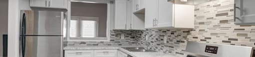 Kitchen at Mirador at Idlewood in Clarkston, GA, featuring energy-efficient appliances including refrigerator, gas stove, dishwasher, and garbage disposal; select units offer upgraded stainless steel finishes.