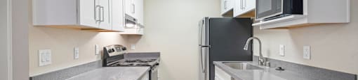 1 Bedroom Apartments in Fremont, CA - Lincoln Glen - An interior shot of the kitchen, featuring white cabinets and stainless steel appliances