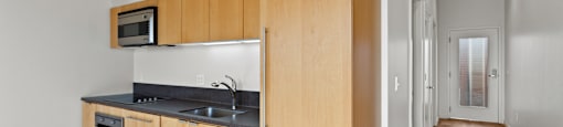 A kitchen with wooden cabinets and a microwave above the stove.