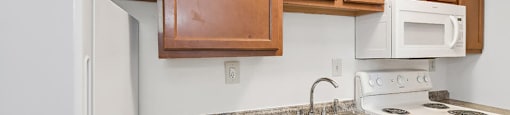 apartment kitchen with appliances and wooden cabinets