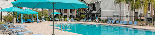 our apartments have a swimming pool with chairs and umbrellas