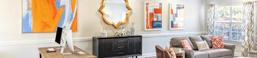 A living room with a brown wooden table and a black cabinet at 1322 North Apartments in Auburn, AL.