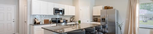 an open kitchen with a large island with bar stools