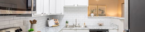 a kitchen with white cabinets and stainless steel appliances