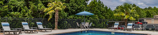 a swimming pool with chairs and umbrellas at the resort