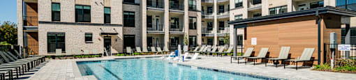 an apartment swimming pool in front of an apartment building