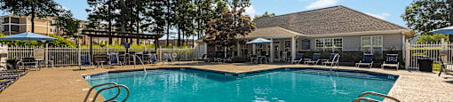 a swimming pool with a house in the background