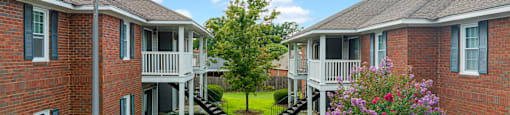 an image of an apartment complex with a walkway and grass