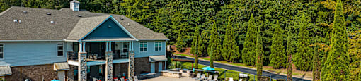 an aerial view of a swimming pool and resort building with umbrellas