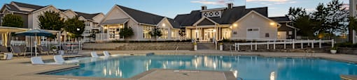 a swimming pool at sunset with houses in the background