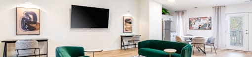 A living room with a green chair and a black television.