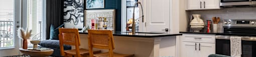 A kitchen with a table and chairs in front of it. at Evolve Waterford Apartments in Belville, NC